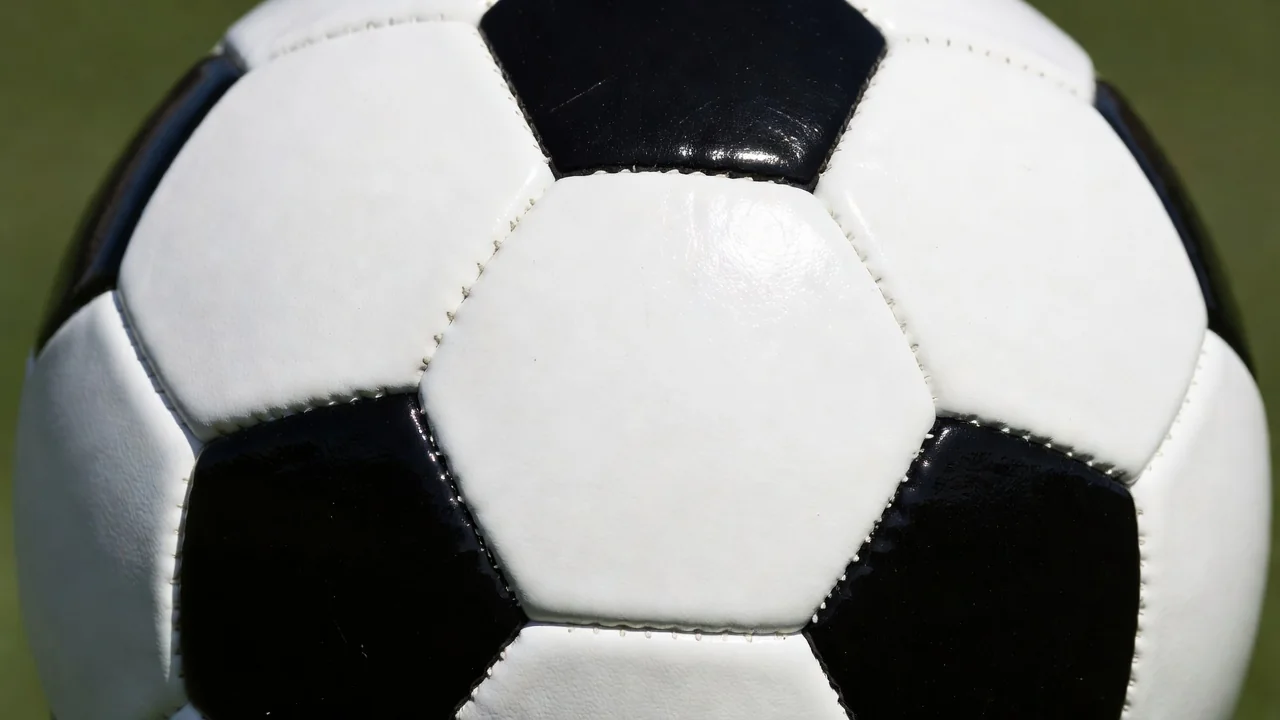 Close-up of a classic black and white soccer ball texture in bright daylight