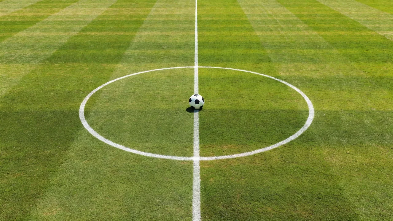 Soccer ball at the exact centre circle mark of a vivid pitch, top-down view