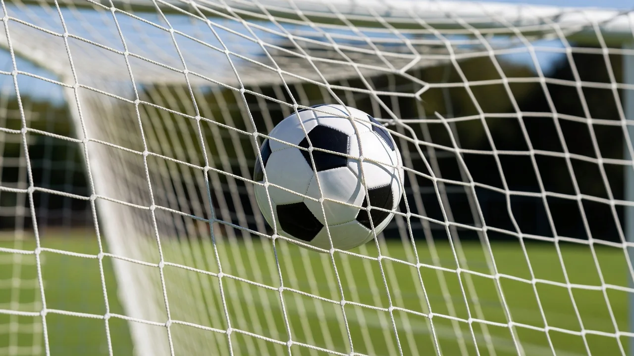 Soccer ball hitting the top corner of a bright white goal net, close-up